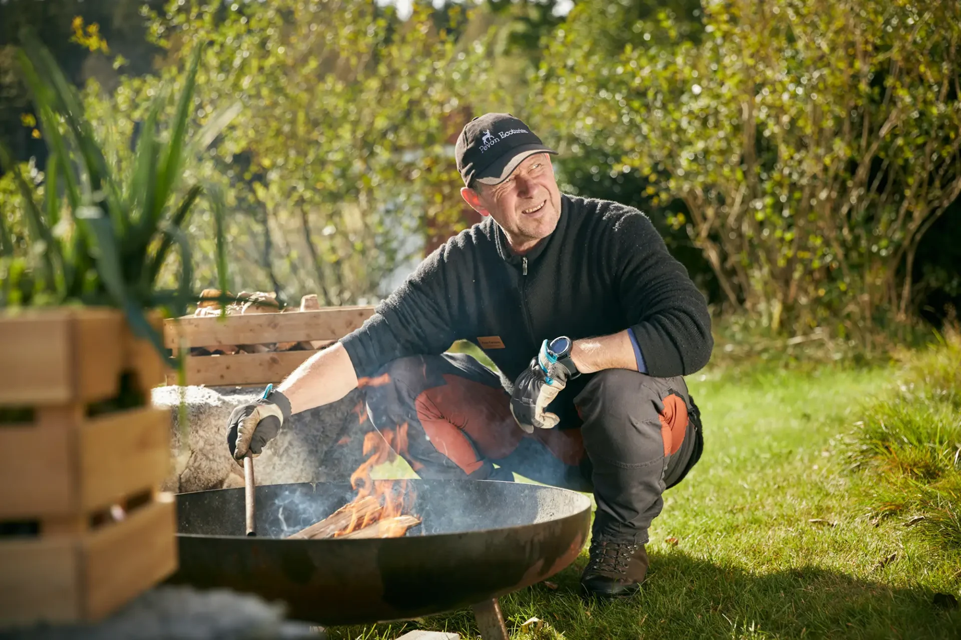 Person grillar mat över öppen eld i naturen under en utomhusaktivitet med Pevon Ecoturism. Foto: Jonas Ingman.