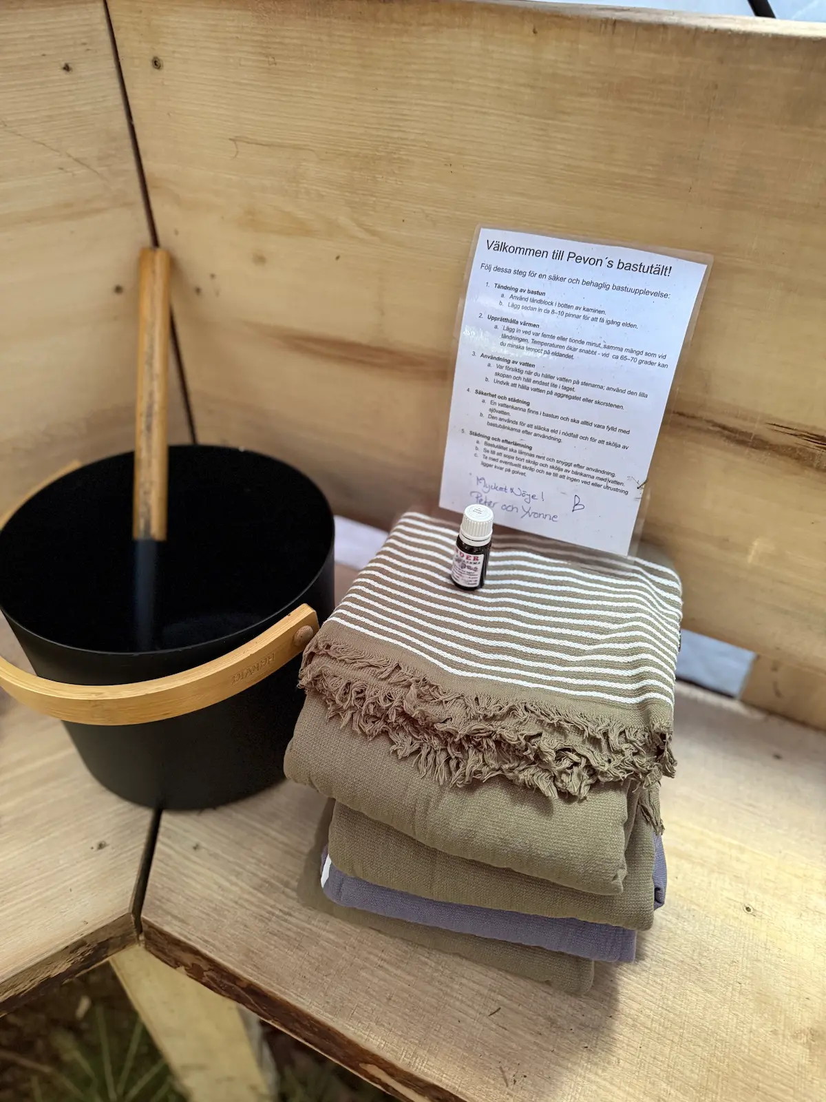 Handdukar som ligger vikta på träbänkarna inne i vårt vedeldade bastutält.