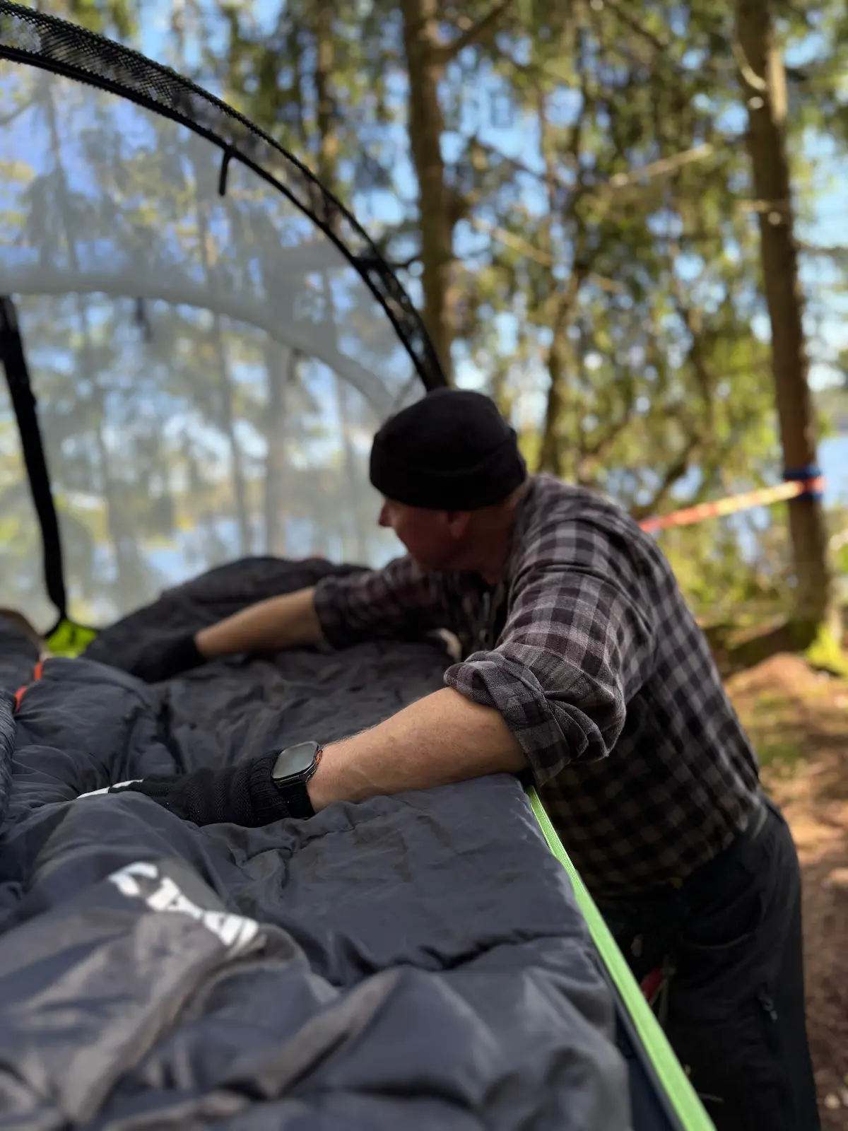 Peter bäddar trädtältet i Hjällsnäs Eco Camp – en del av naturpaketet med hög mysfaktor.